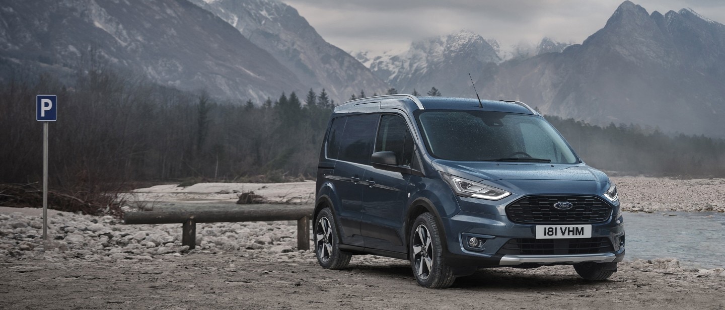 Ford Transit Connect standing by lake in mountains