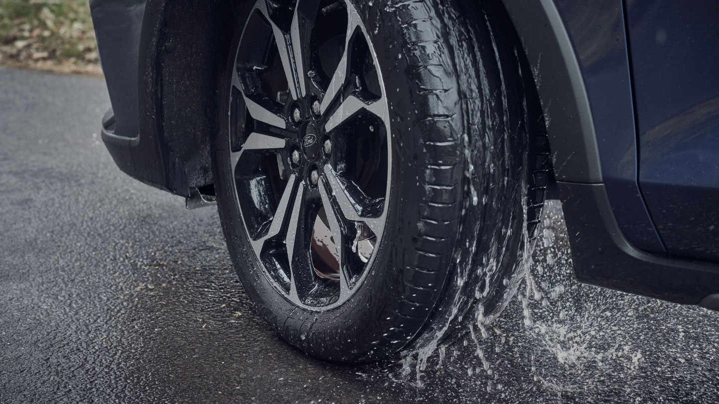 Pneu de voiture roulant sur une route mouillée par temps de pluie