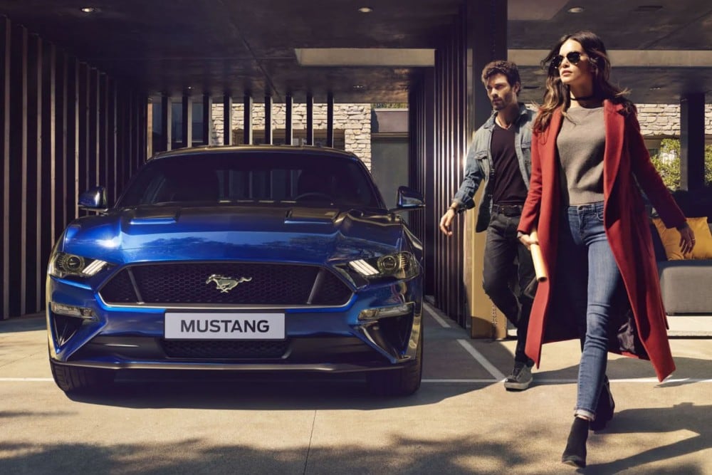 Ford Mustang bleue garée devant la maison