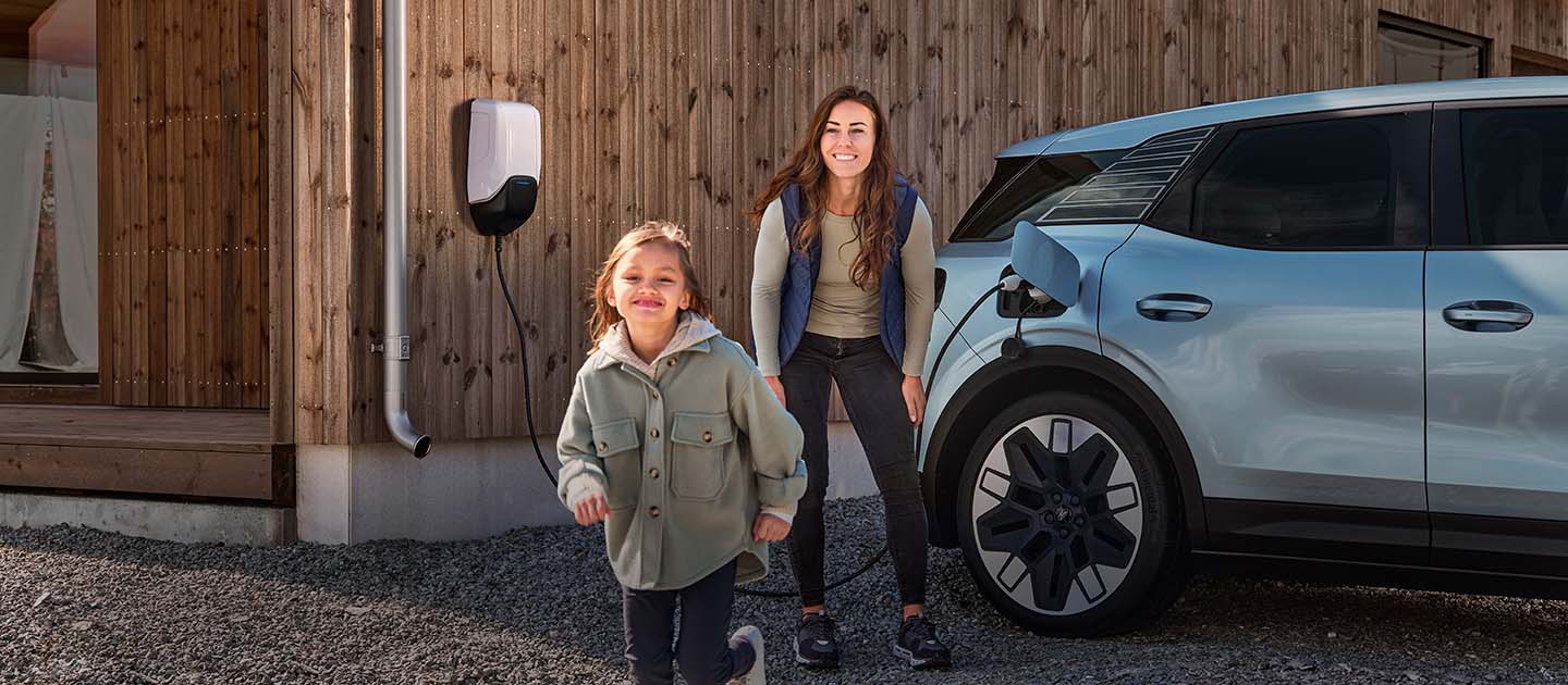 Une famille qui s'amuse pendant la recharge de son Ford Explorer électrique à domicile.