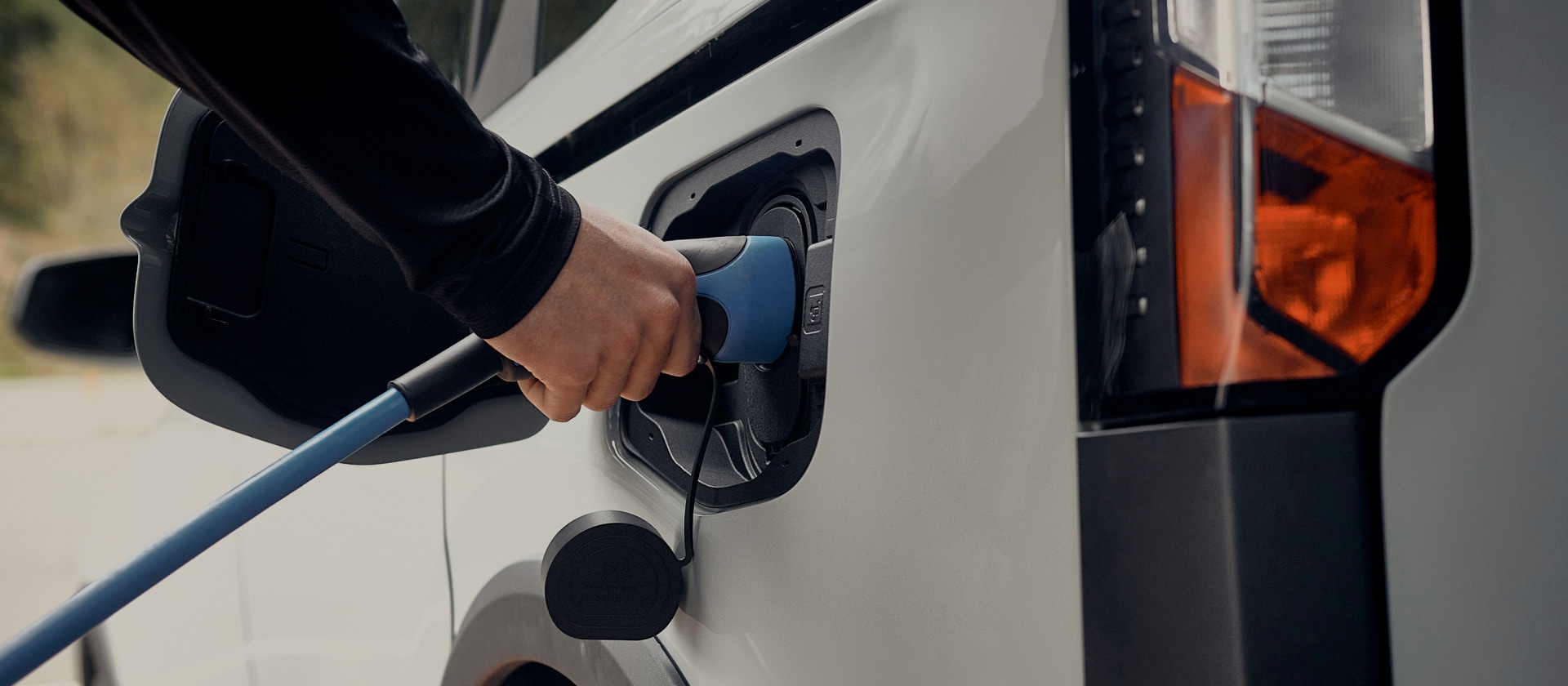 Gros plan d'un véhicule électrique Ford blanc branché sur un chargeur EV.