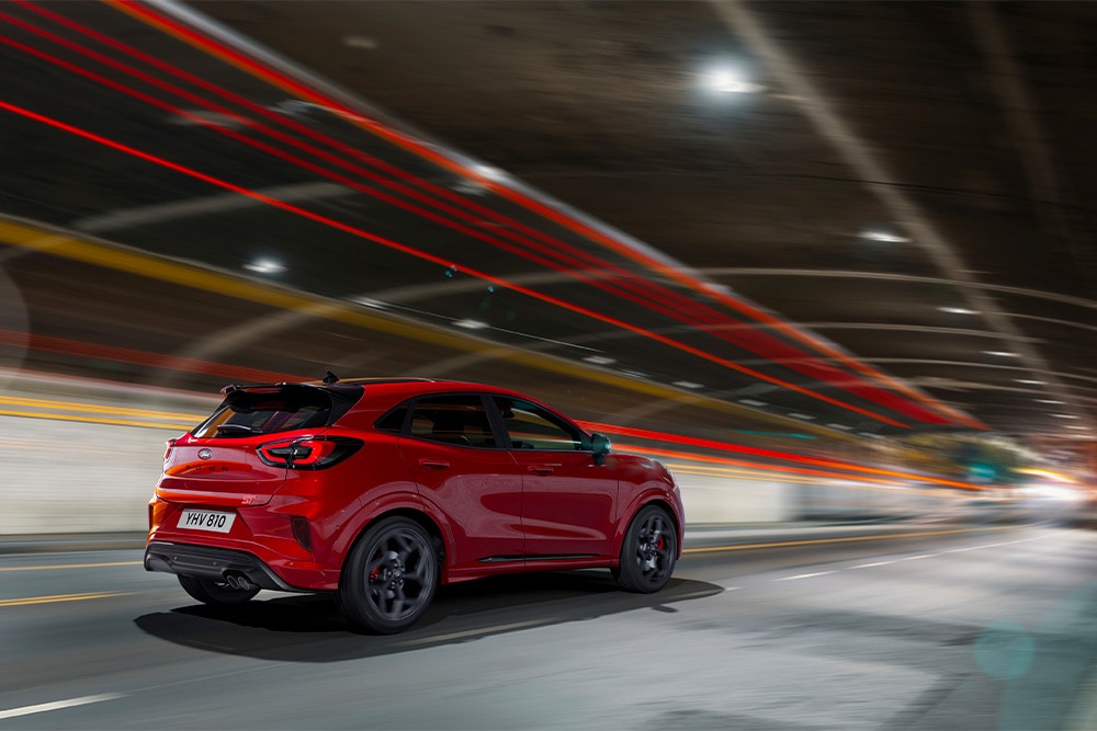 Une Ford Focus mild hybrid rouge traversant un tunnel. 