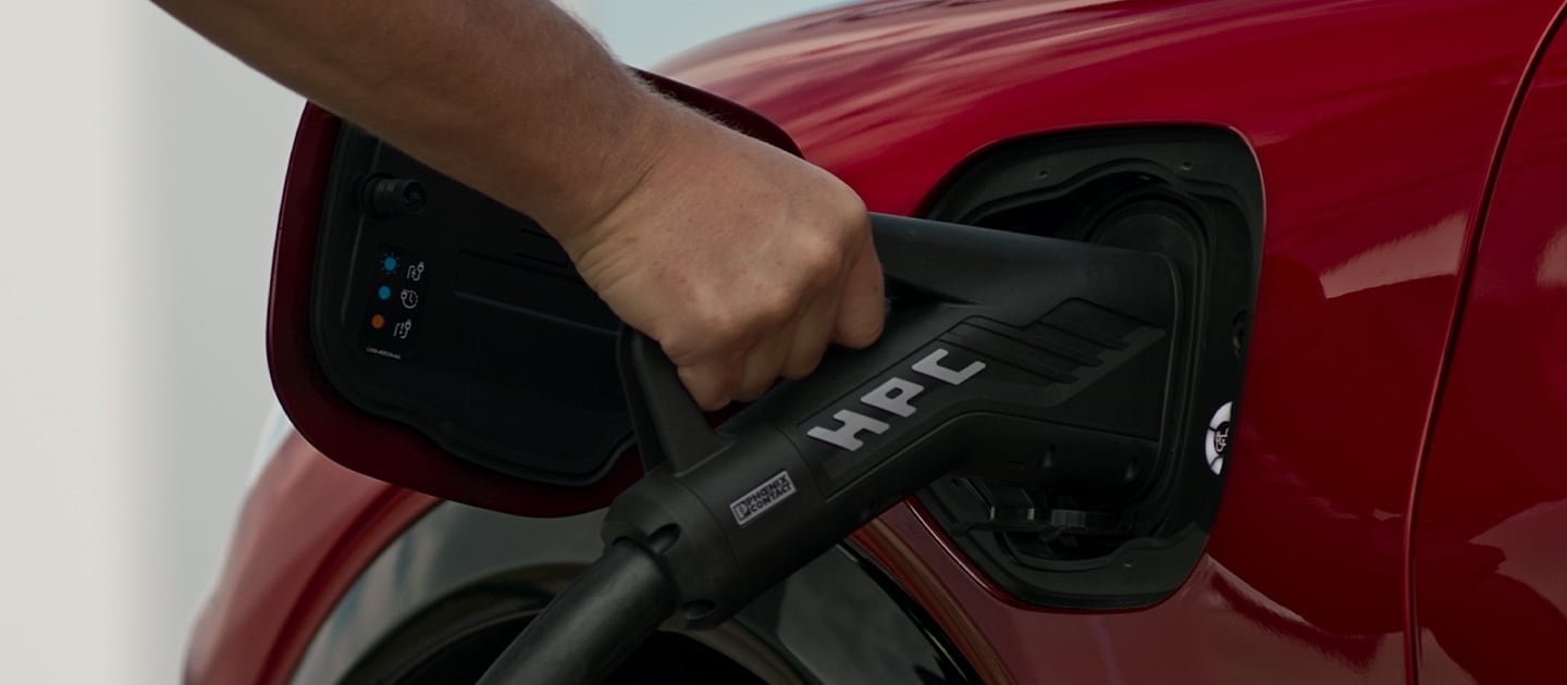 Gros plan d'une Ford EV rouge connectée à un HPC (High Power Charger) public, pour une recharge publique rapide des VE.