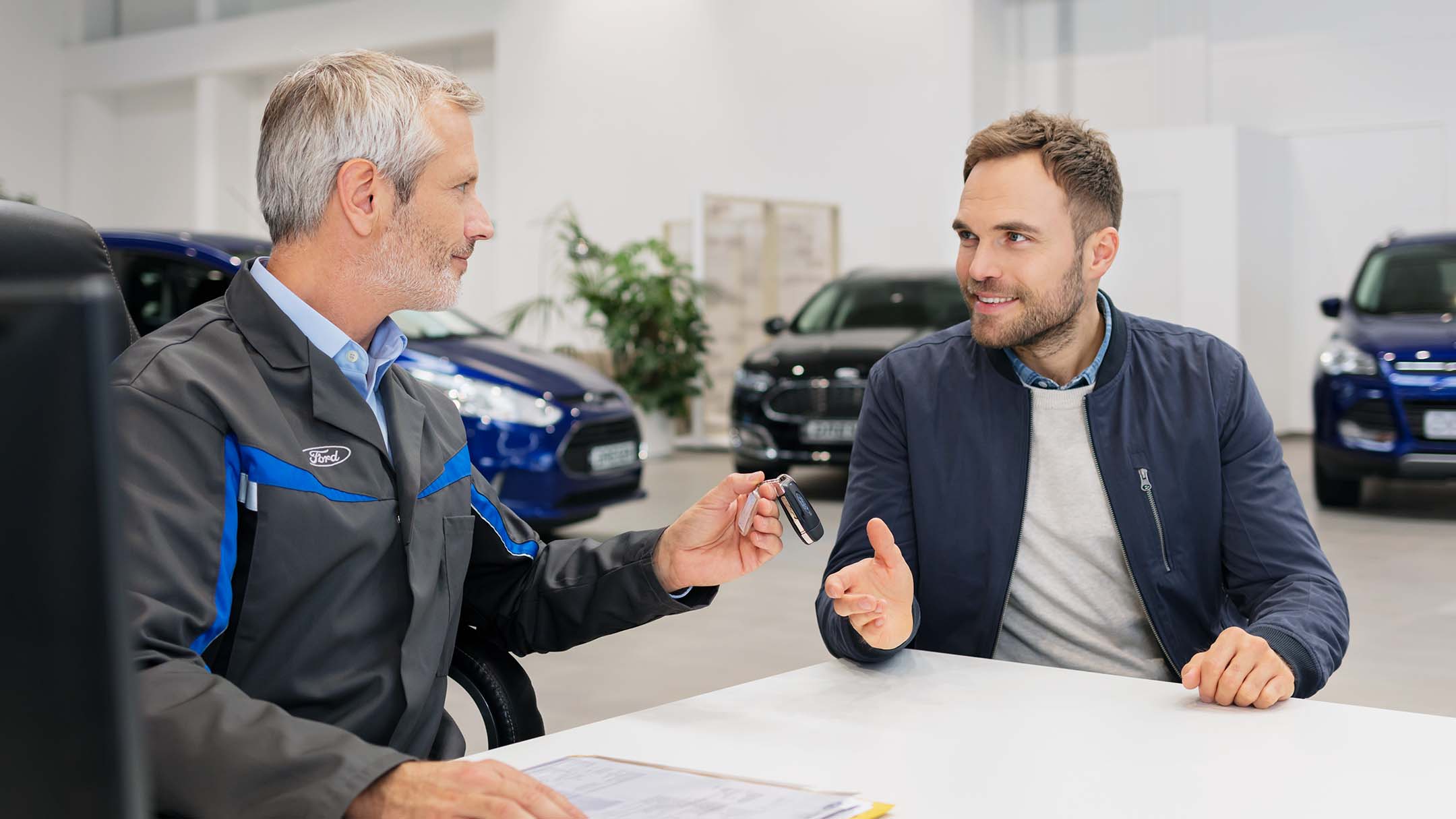 The service employee passes the keys to the owner