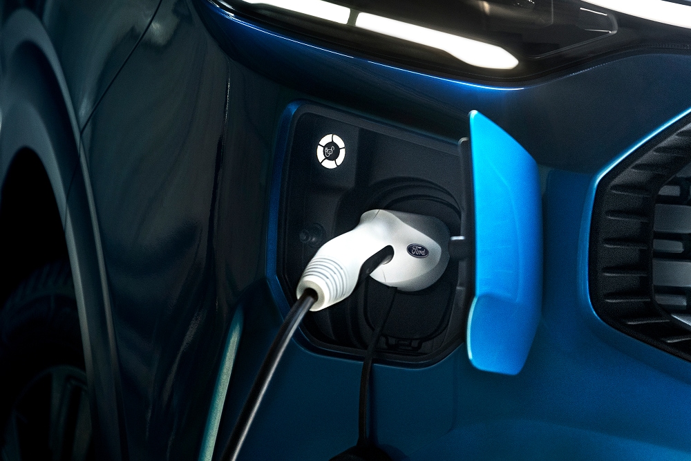 Gros plan sur un câble de recharge électrique branché sur un fourgon électrique Ford E-Transit Custom.