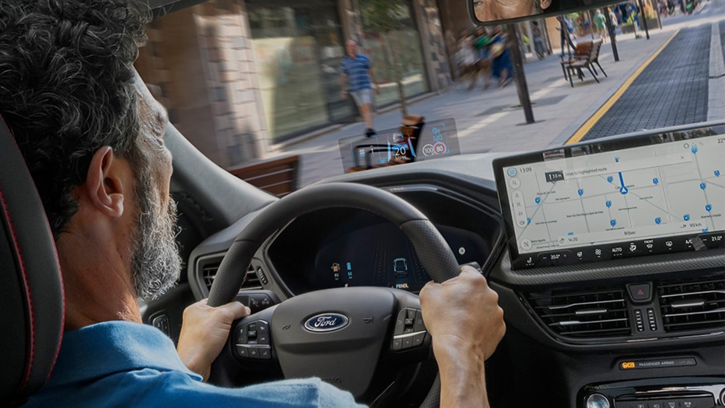 Photo intérieure d’un homme conduisant la Ford Kuga sur une route urbaine.