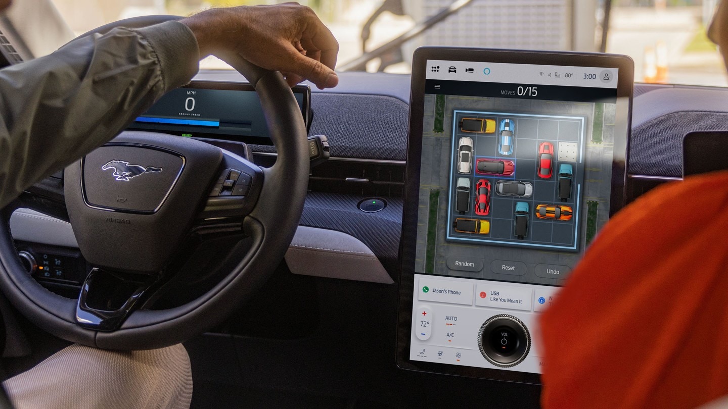 Habitacle de la Ford Mustang Mach-E, montrant le volant et le grand écran tactile SYNC.