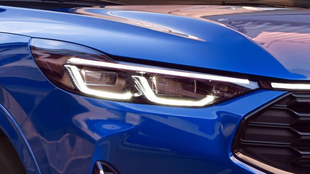 Gros plan du phare avant d’une Ford Mustang Mach-E bleue.