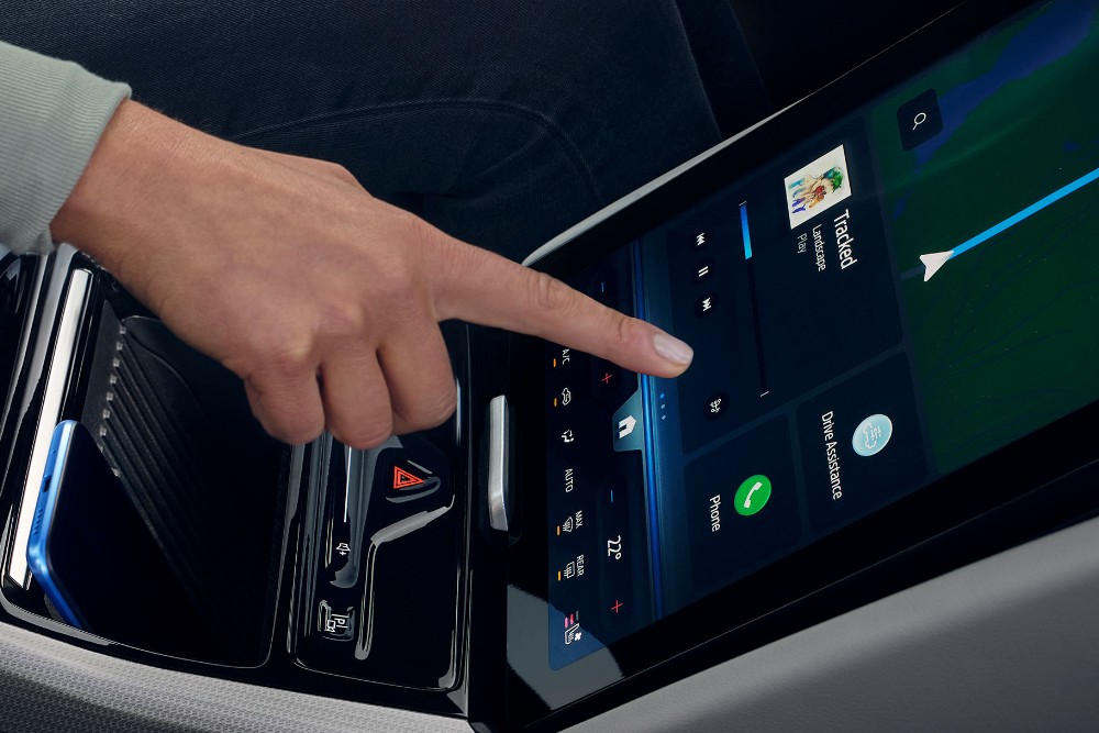 Une femme interagissant avec le grand écran tactile SYNC à bord du Ford Explorer. 