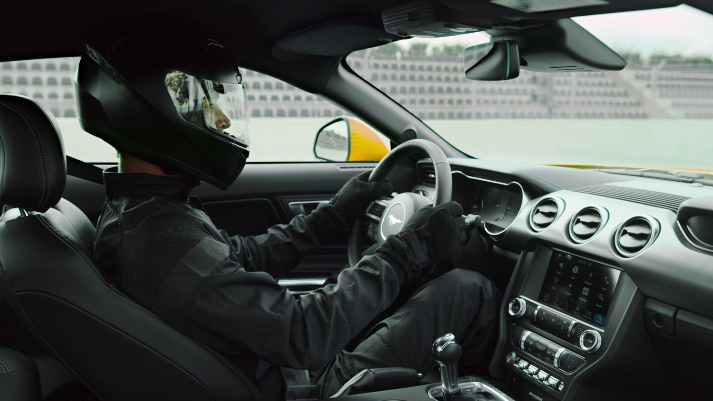 Un pilote de course à l’intérieur d’une Ford Mustang.