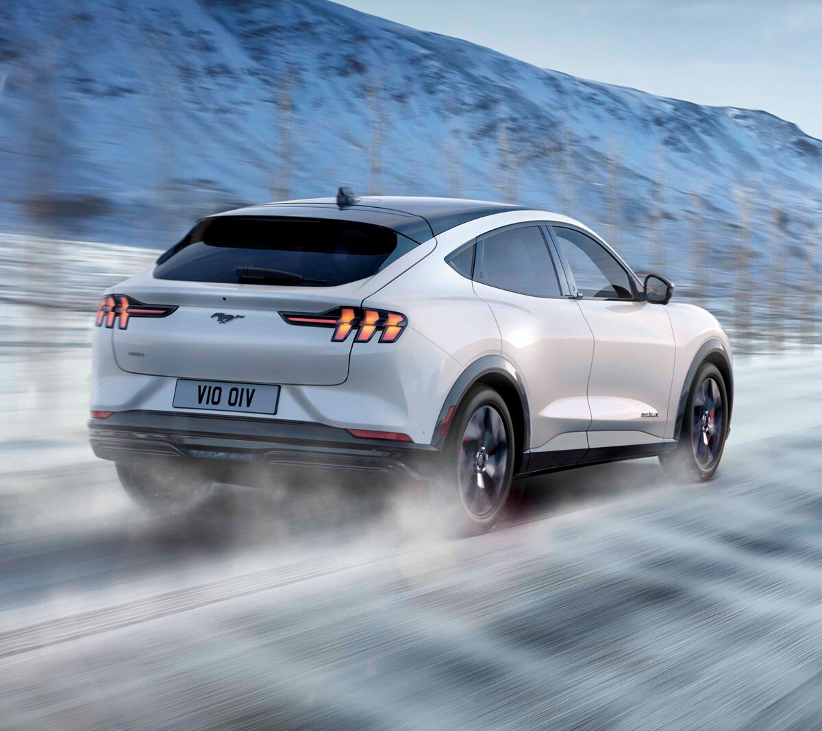 Vue arrière de la Ford Mustang Mach-E roulant dans la neige.