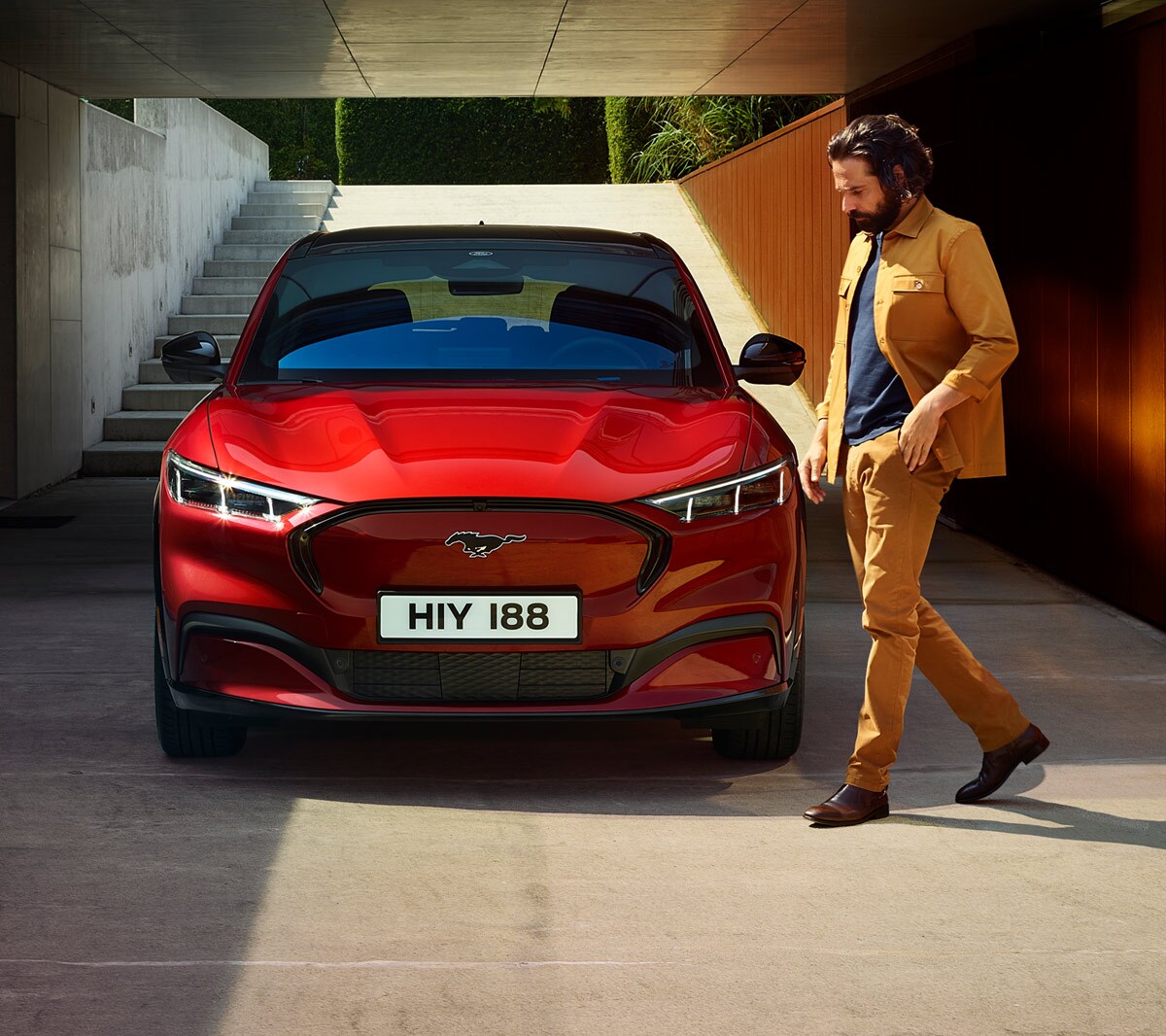 Vue avant de la Ford Mustang Mach-E garée avec un homme à côté.