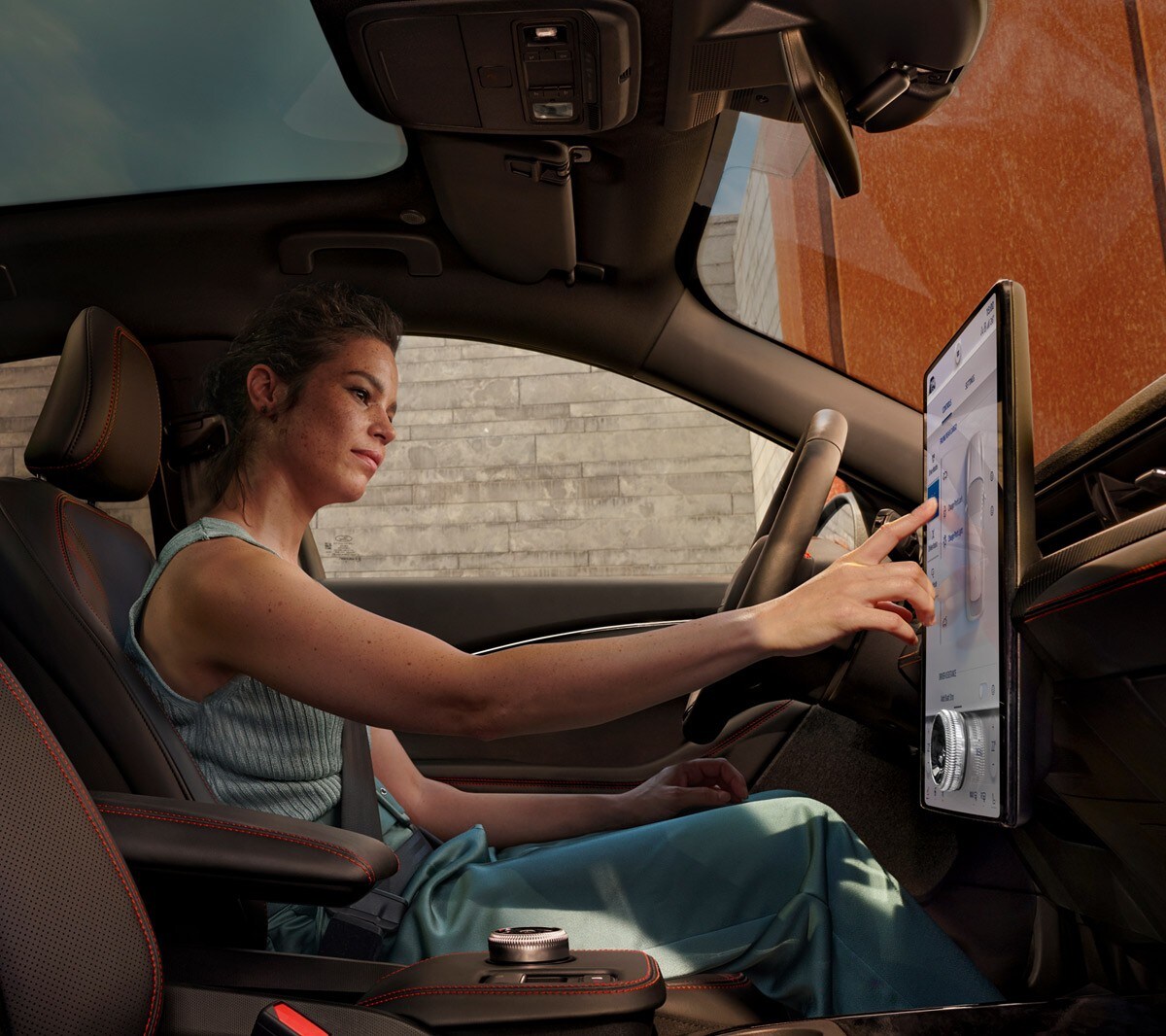Vue intérieur de la Ford Mustang Mach-E avec une femme utilisant SYNC 4.