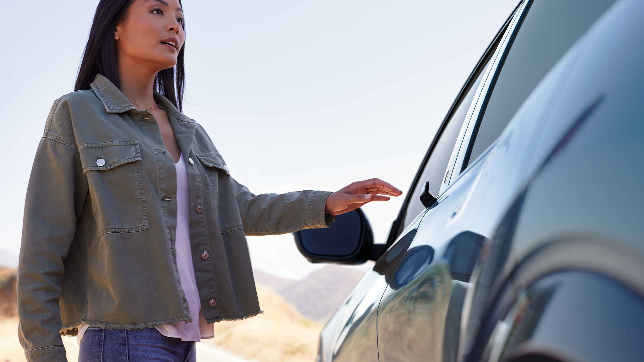 Une femme approchant de sa Ford Mustang Mach-E pour ouvrir la porte.
