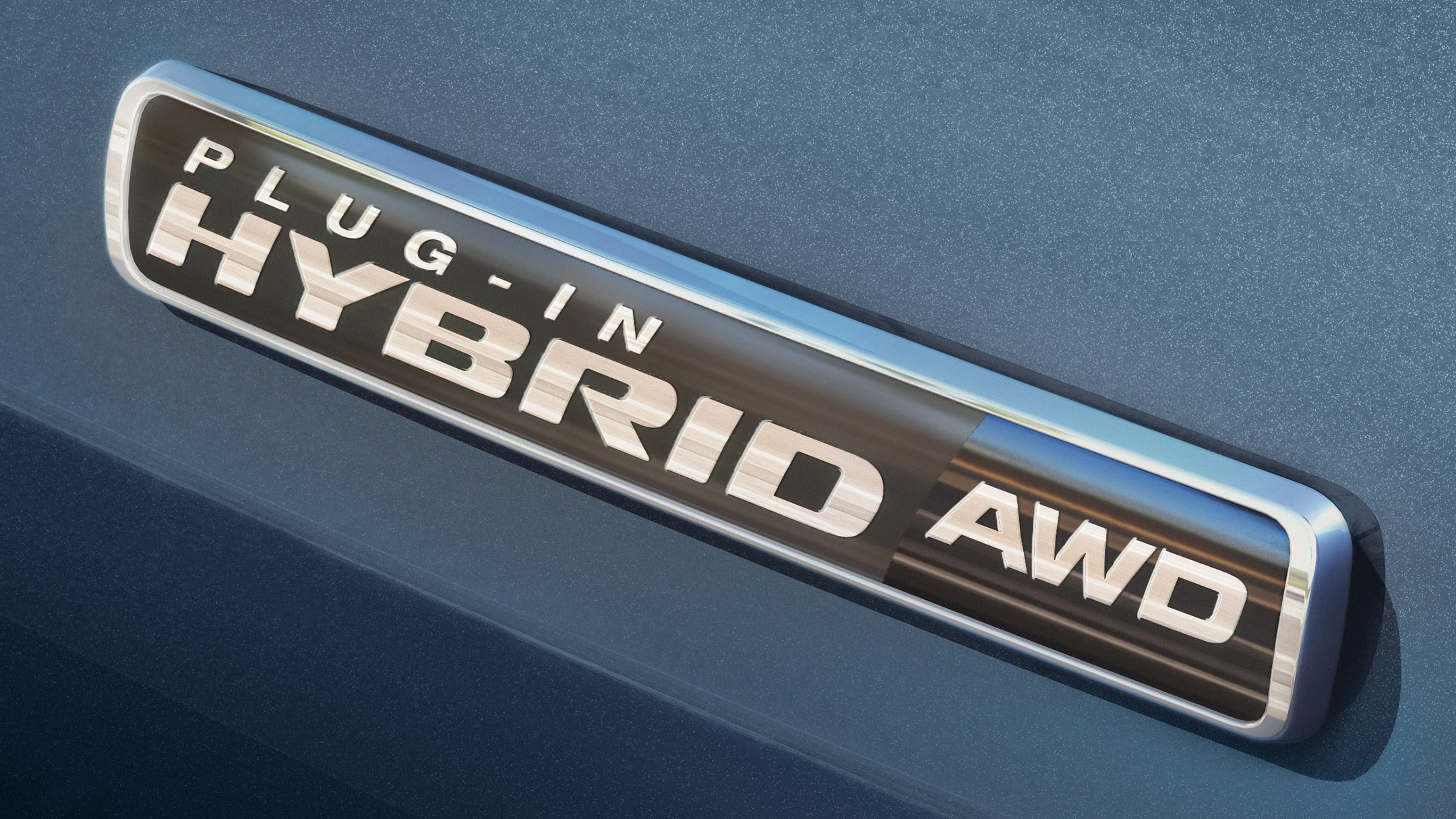 Gros plan sur le badge hybride rechargeable du Ford Explorer. 