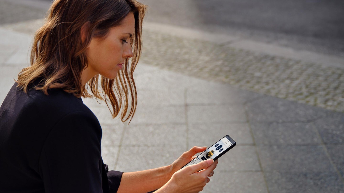 Une femme consultant FordPass depuis son téléphone portable.