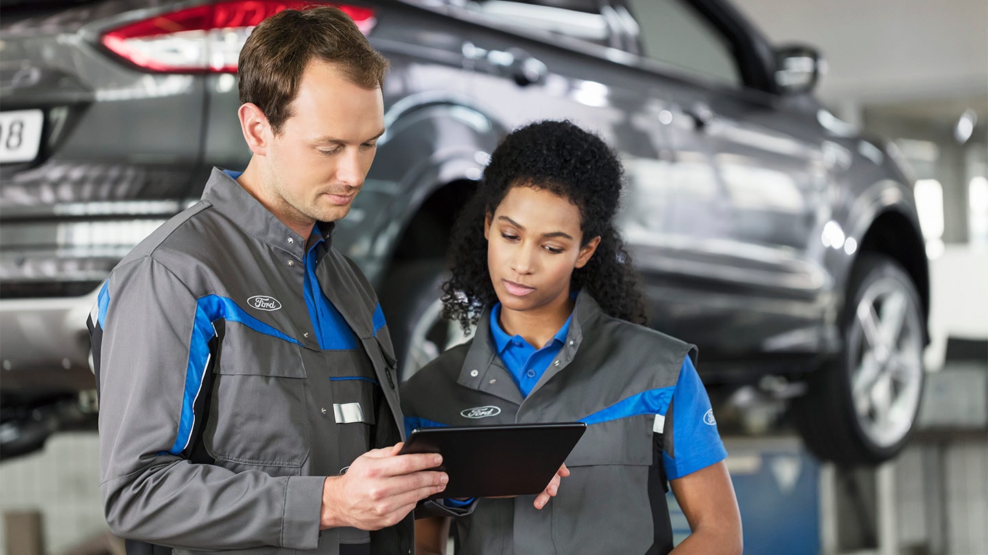 Deux réparateur Ford qui regarde les reservations en ligne sur le système