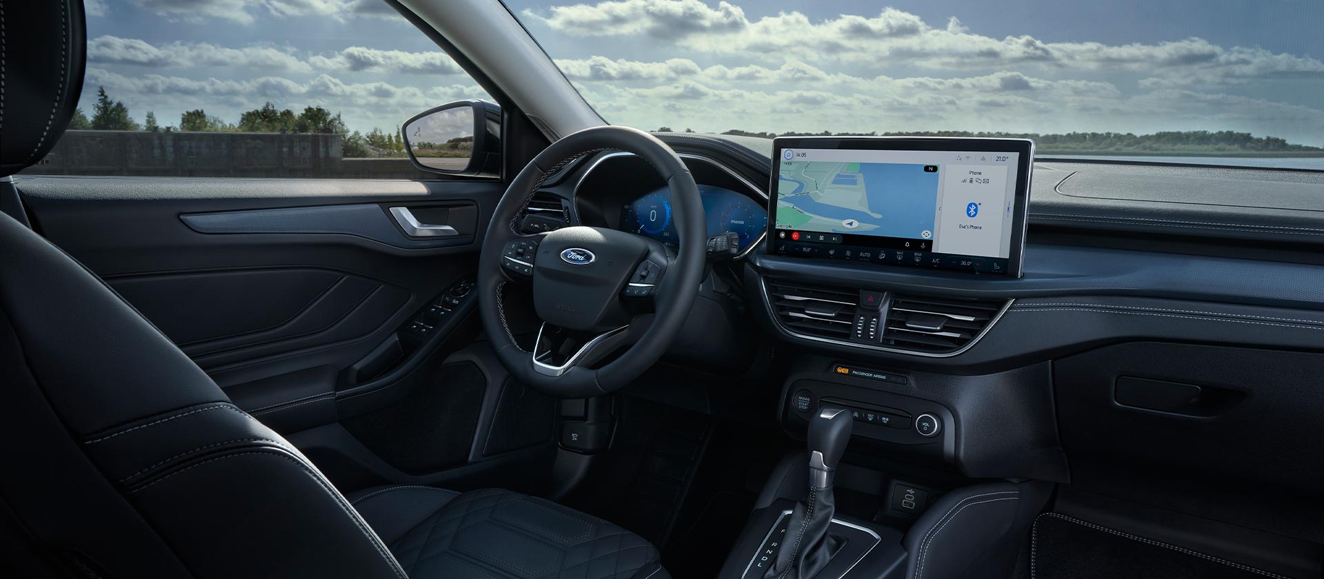 Vue intérieure de la Ford Focus, montrant le tableau de bord, l'écran d'infodivertissement avec navigation et le volant.