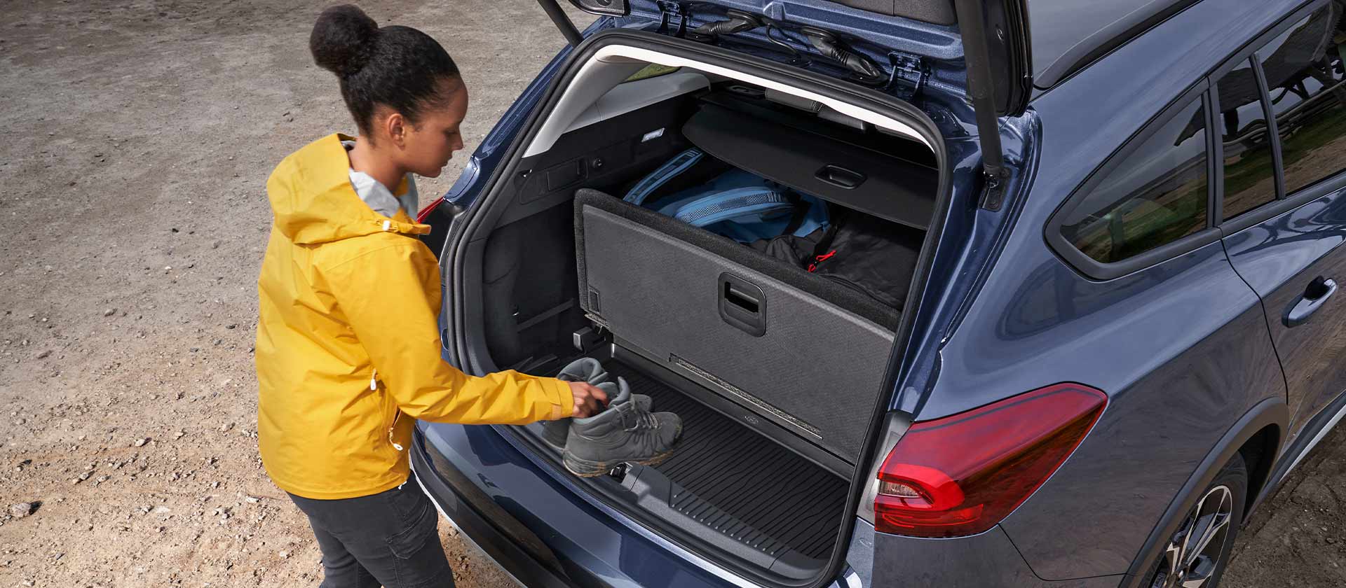 Femme rangeant des chaussures dans le coffre d'une Ford Focus