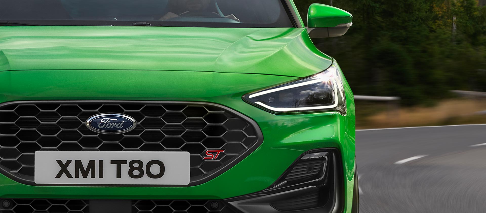 Vue avant de la Ford Focus ST vert moyen, montrant la calandre en nid d'abeille et le badge ST.