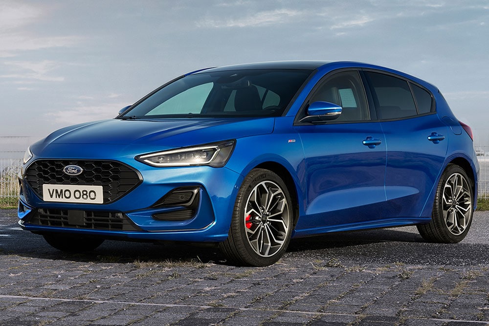 Une Ford Focus ST-Line bleue à hayon avec des étriers de frein rouges, garée sur une surface pavée.
