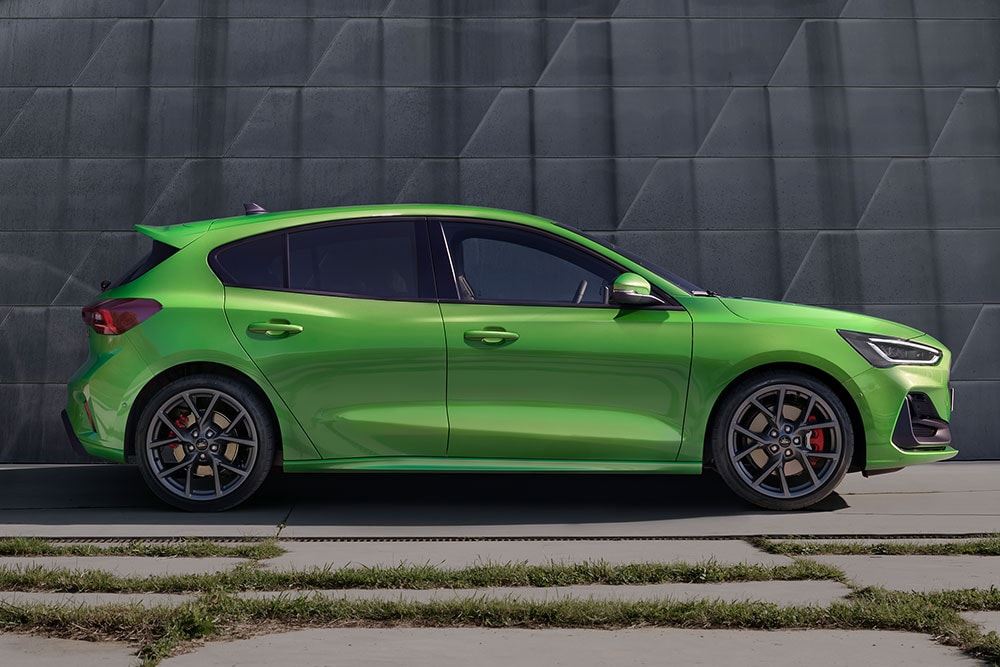Le côté d'une Ford Focus ST à hayon vert foncé garée en dehors de la route.