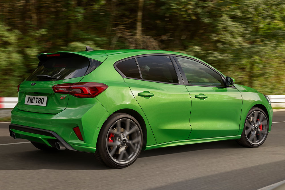 Vue arrière d'une Ford Focus ST à hayon de couleur vert foncé roulant sur un circuit.