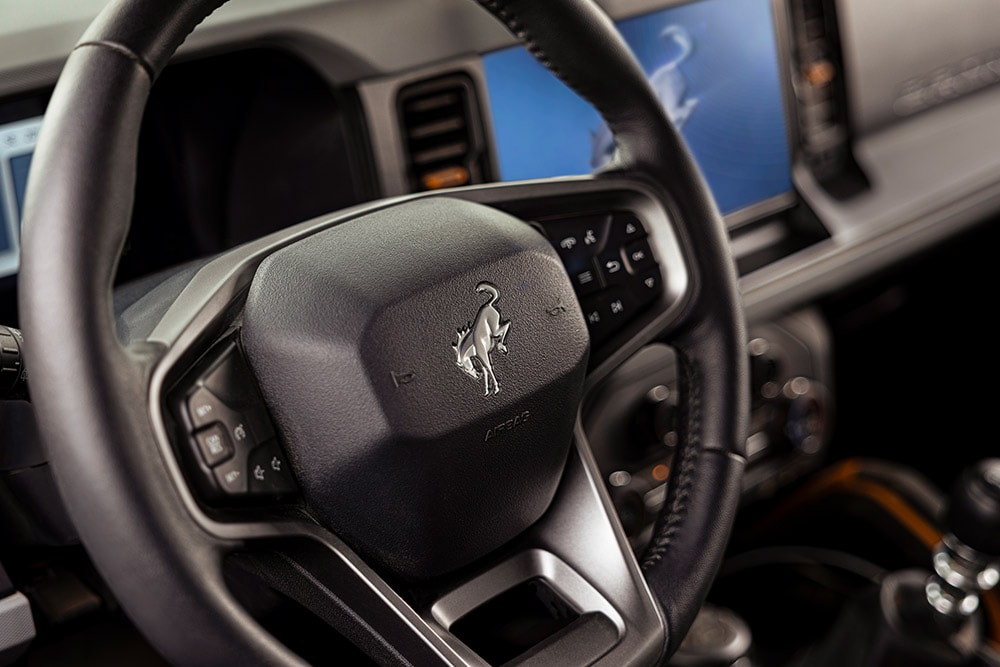 A close up on the branded leather steering wheel of the Ford Bronco.