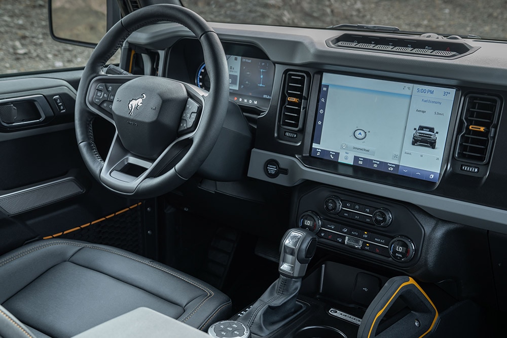 View of the Ford Bronco interior, including the leather steering wheel and connected touchpad.