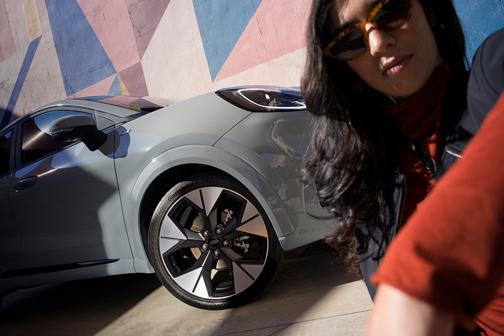 Un gros plan d’une personne près d’une Ford Puma® grise avec un moteur EcoBoost® à essence.