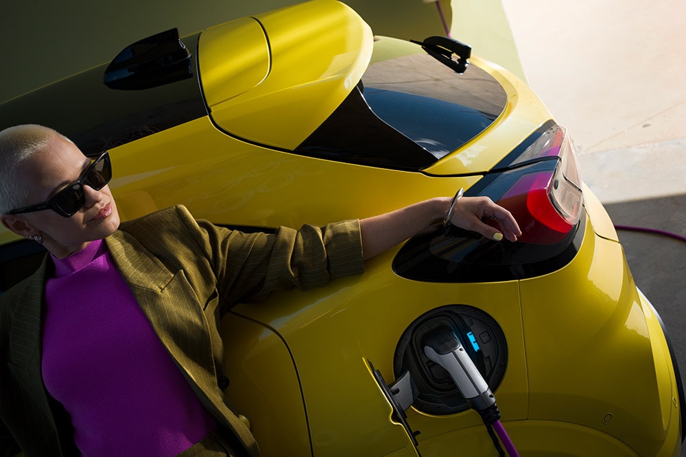 Un gros plan de l’arrière de la Ford Puma Gen-E® électrique, branchée à une borne de recharge murale à domicile.