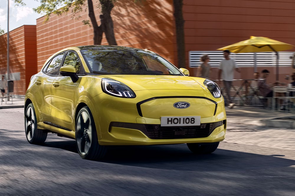 Vue avant d’une Ford Puma Gen-E® électrique jaune circulant en ville.