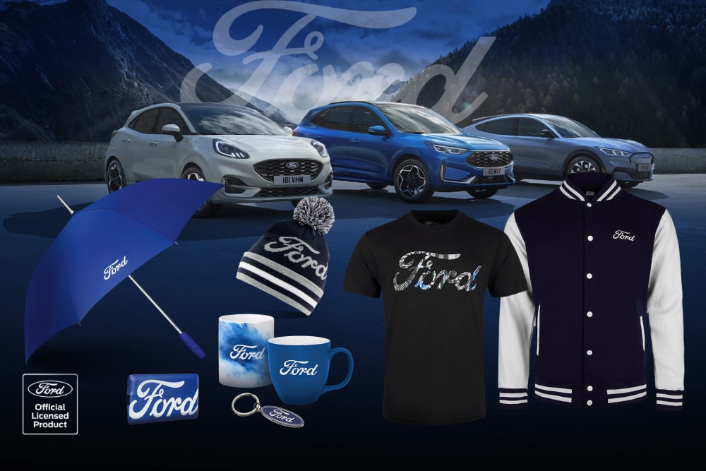 Collection d’articles Ford avec divers véhicules Ford en arrière‑plan, ainsi qu’un parapluie, des mugs et des vêtements siglés Ford.