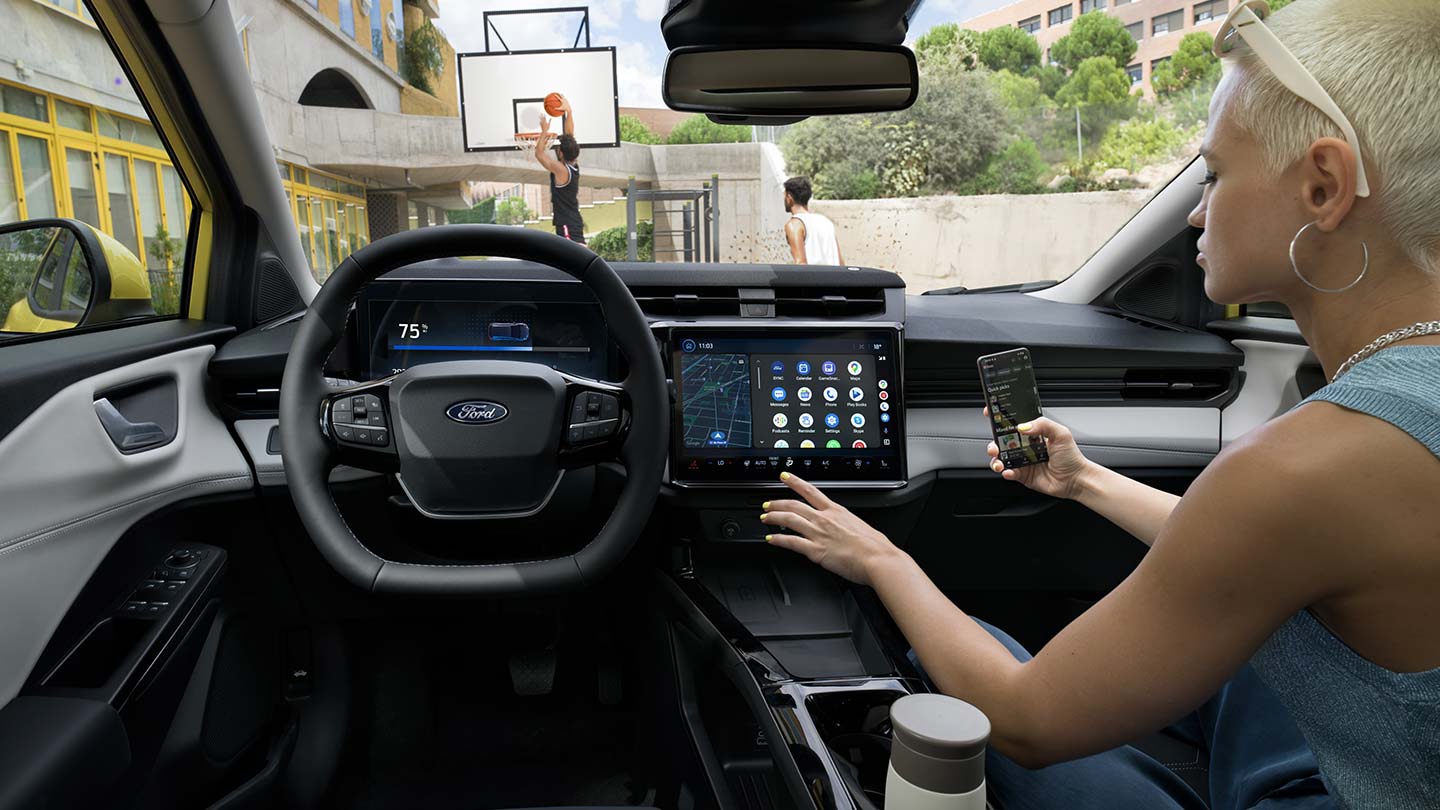 L’intérieur de la Ford Puma Gen-E® électrique, avec une personne qui synchronise sans fil son téléphone à l’écran tactile.