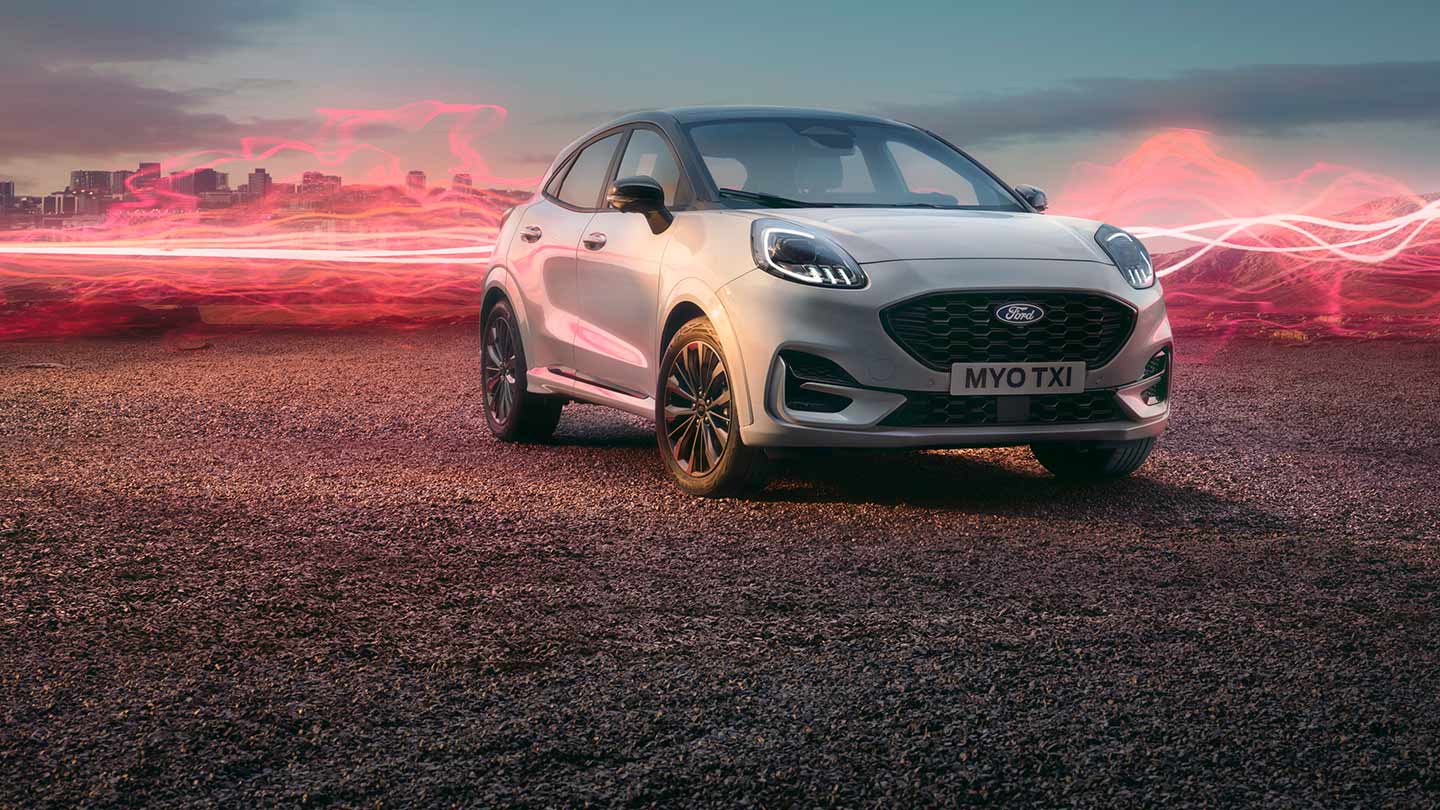 Le modèle Ford Puma Sound Edition en blanc, garé avec des ondes sonores rouges en arrière-plan.
