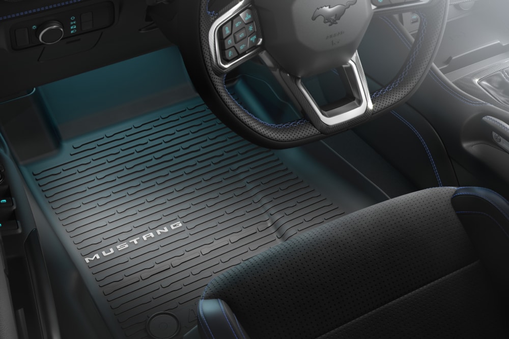 Intérieur d’une Ford Mustang : volant et tapis de sol toutes saisons marqué « MUSTANG ».