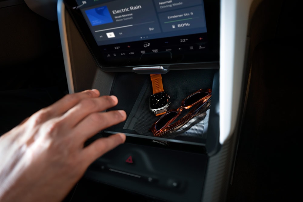 Une main se dirige vers le compartiment My Private Locker (casier secret) dans la Ford Capri®, dévoilant une montre et une paire de lunettes de soleil à l’intérieur.