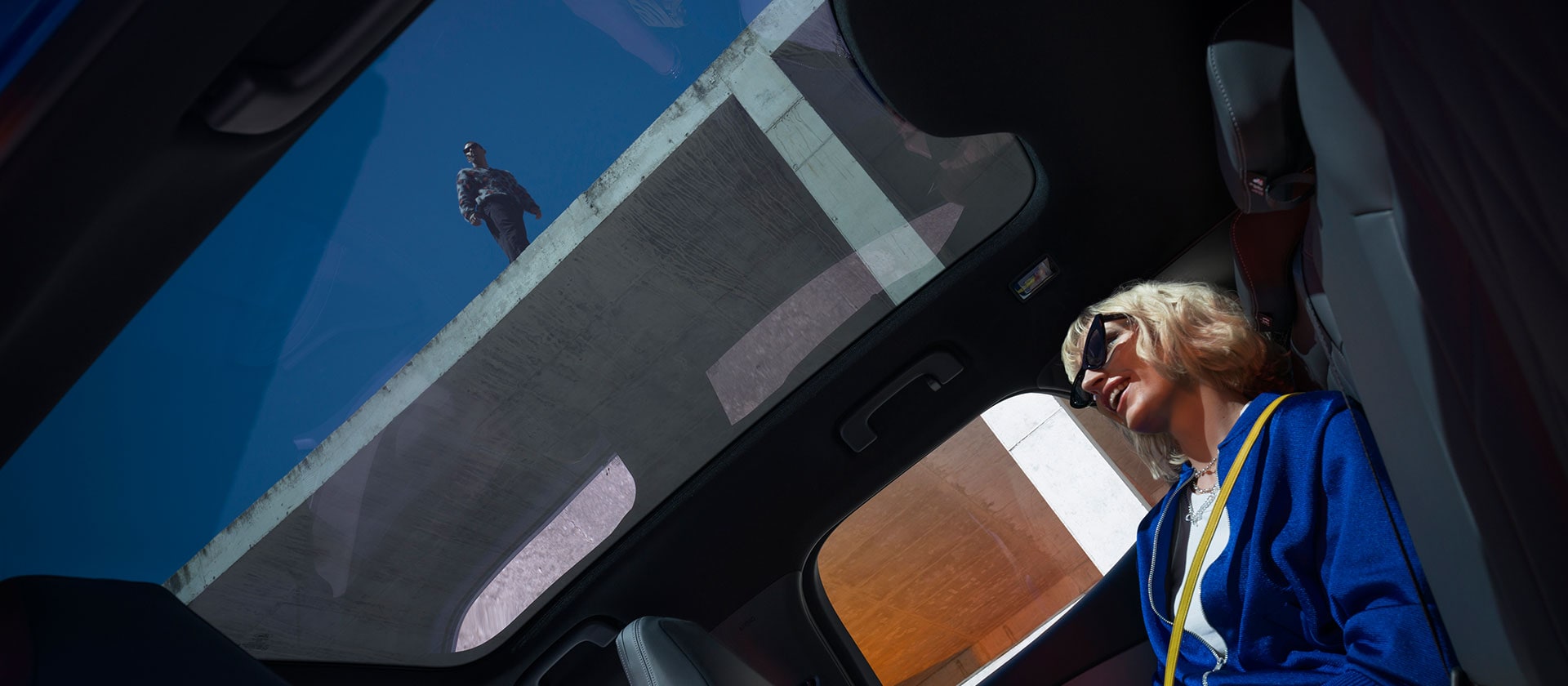 Une personne assise à l'intérieur de la nouvelle Ford Capri profitant de la vue du toit panoramique.