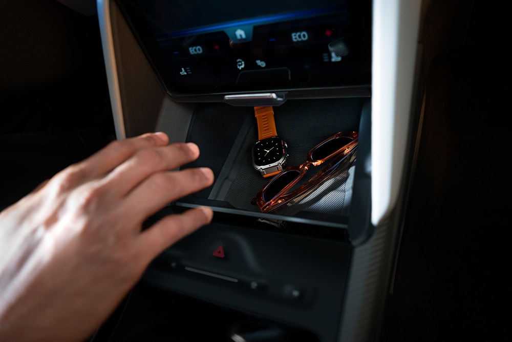 Une main se dirige vers le compartiment My Private Locker (casier secret) dans la Ford Capri®, dévoilant une montre et une paire de lunettes de soleil à l’intérieur.