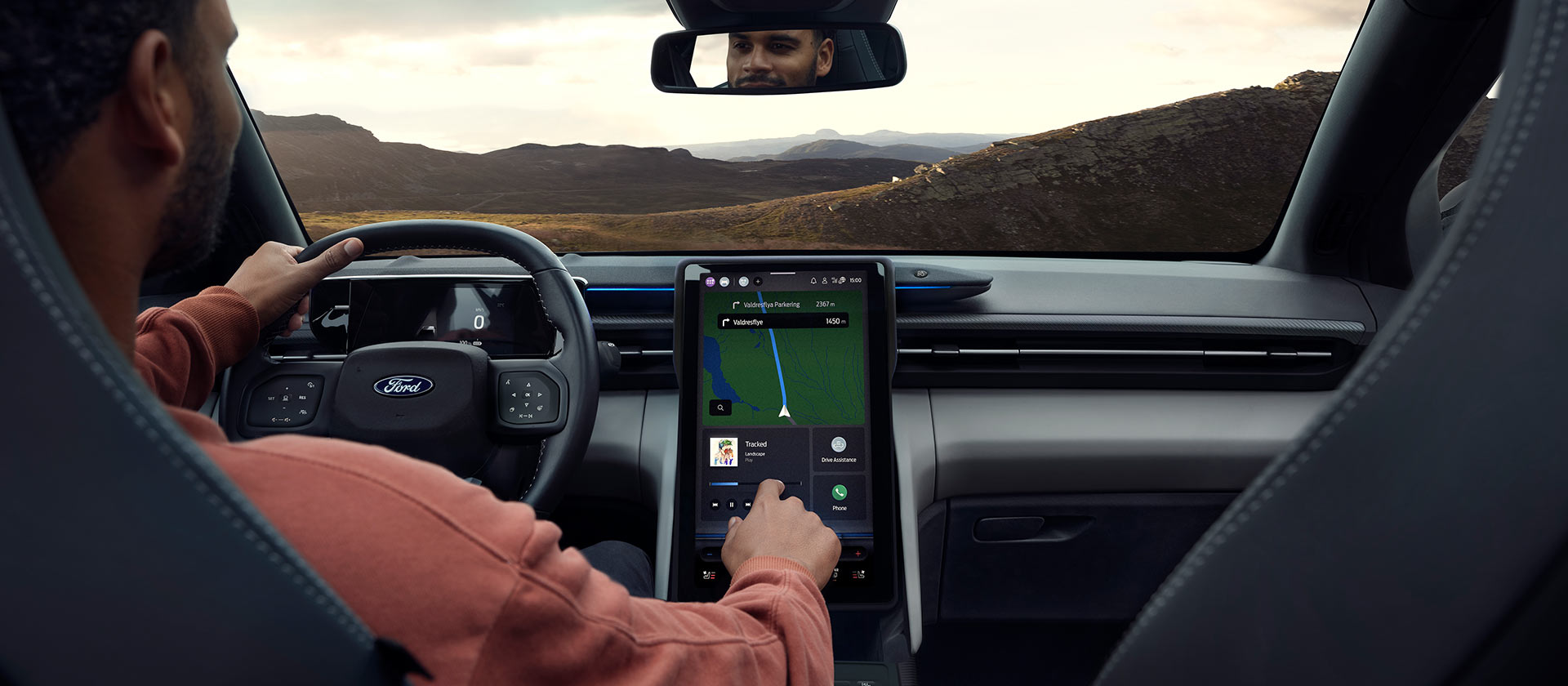 Une personne conduisant le Ford Explorer électrique sur une route de campagne et réglant la musique sur le grand écran tactile SYNC Move de 14,6’’.