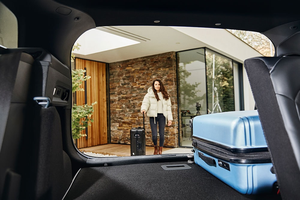 Le compartiment à bagages arrière du Ford Explorer vu de l’intérieur de la voiture avec une valise bleue.