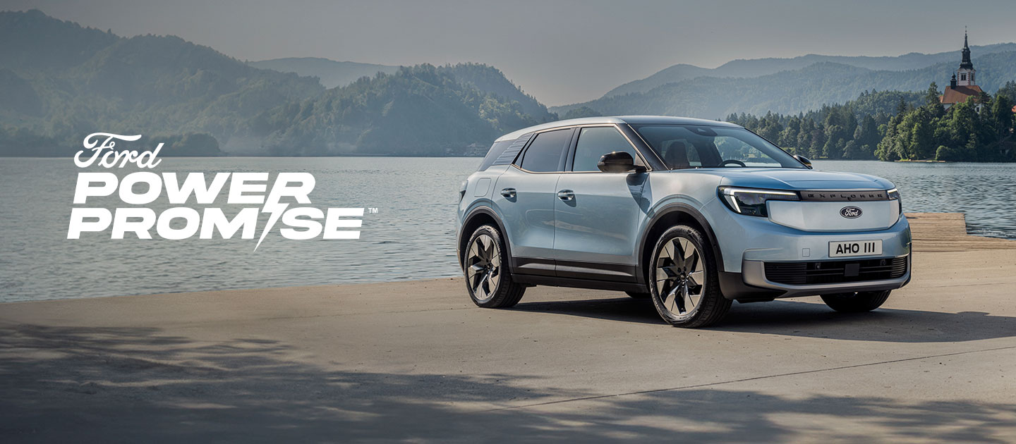 Nouveau Ford Explorer 100% électrique bleu arctique garé au bord d’un lac.