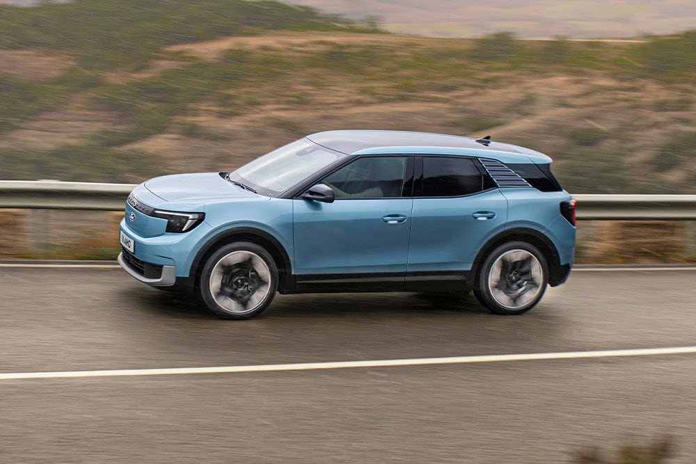 Ford Explorer bleu roulant sur une route de montagne, avec le logo Euro NCAP 2024 cinq étoiles dans le coin supérieur gauche