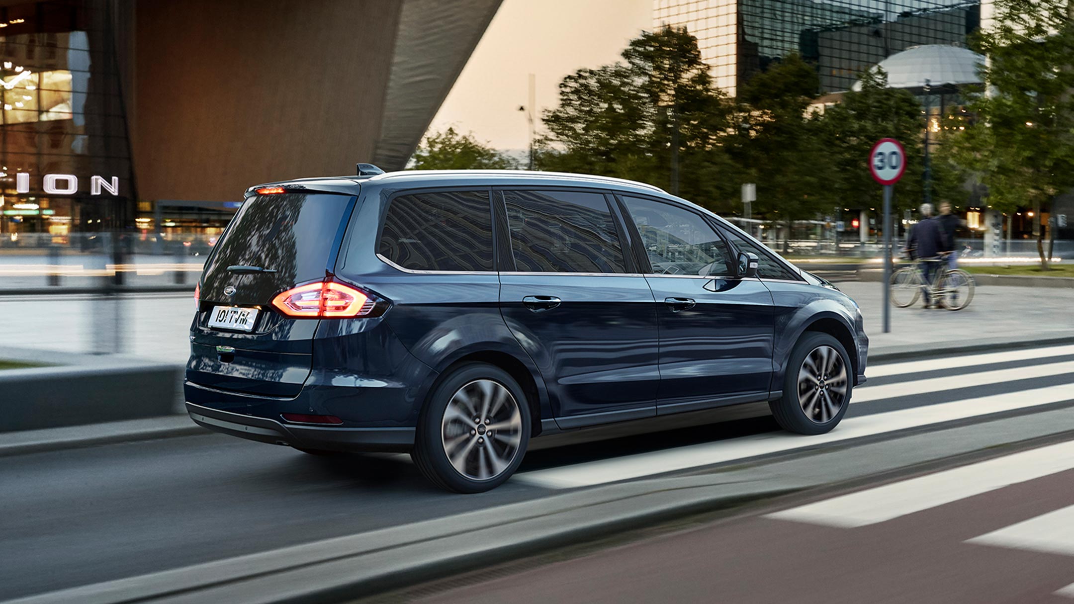 Blue Ford Galaxy in motion with a traffic sign in the background