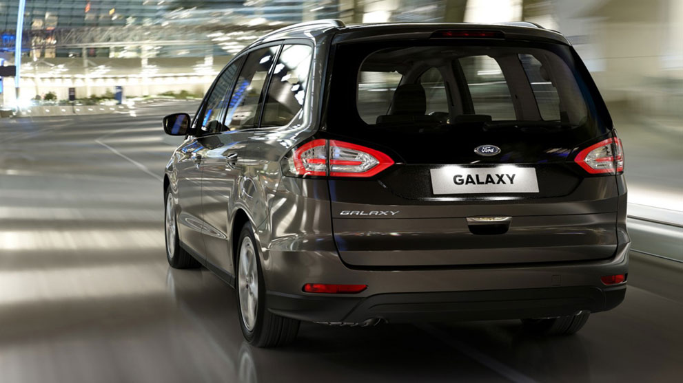 Black Ford Galaxy in motion rear view