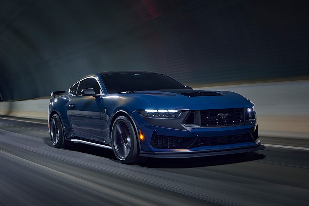 Une voiture de sport Ford Mustang bleu clair traversant un tunnel.