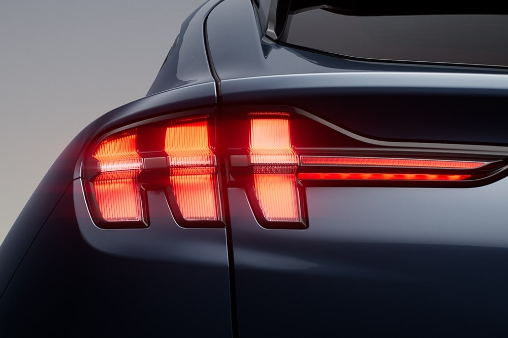 Gros plan sur les trois feux arrière allumés d’une voiture sportive Ford Mustang Mach-E.