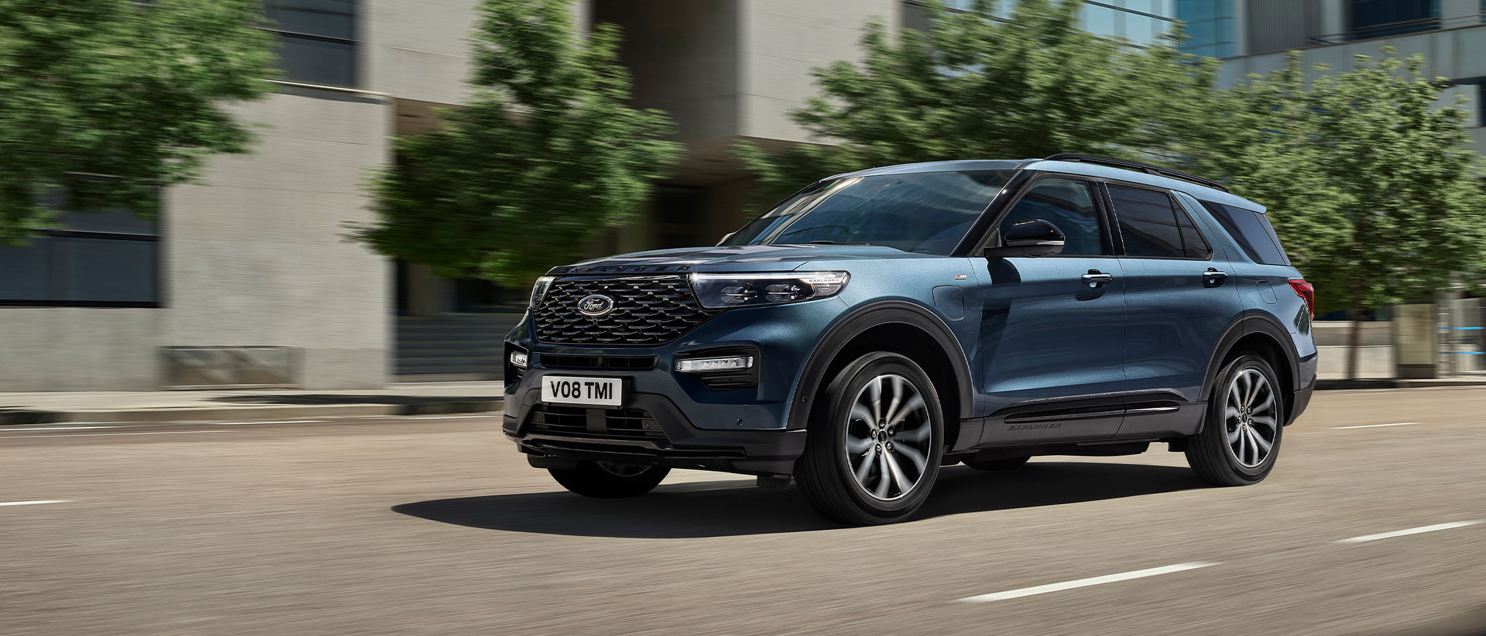 Blue Ford Explorer driving on an city road.