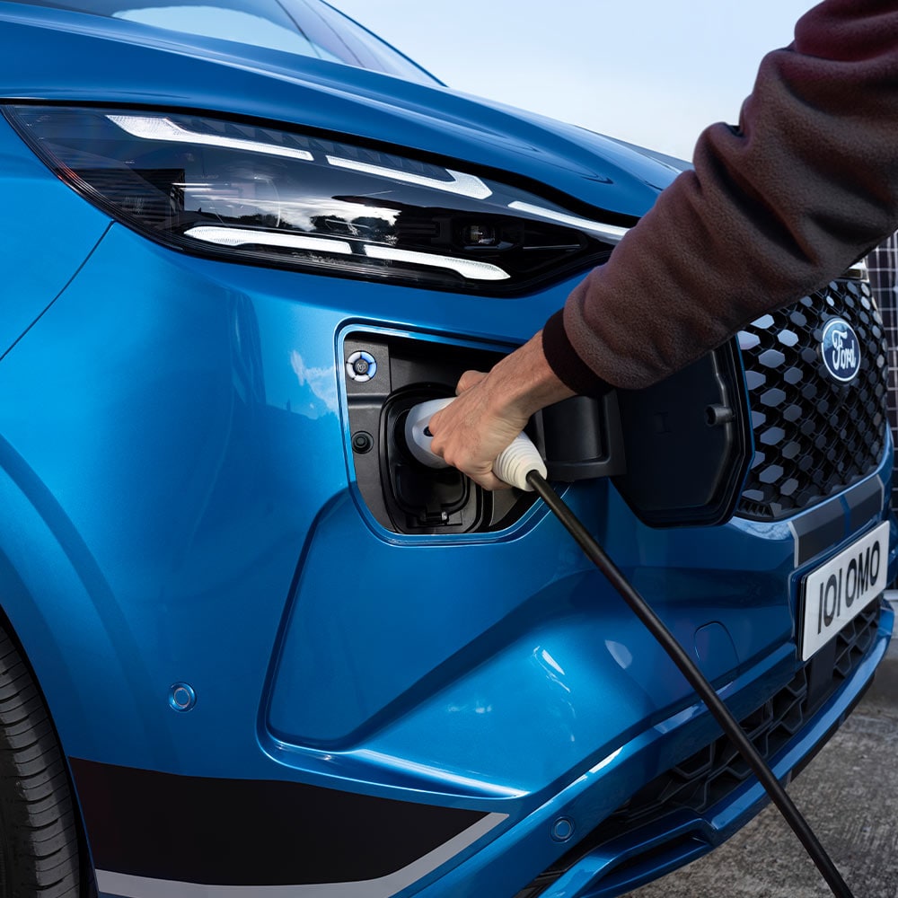 Person plugging in the All-New Tourneo Custom to charge