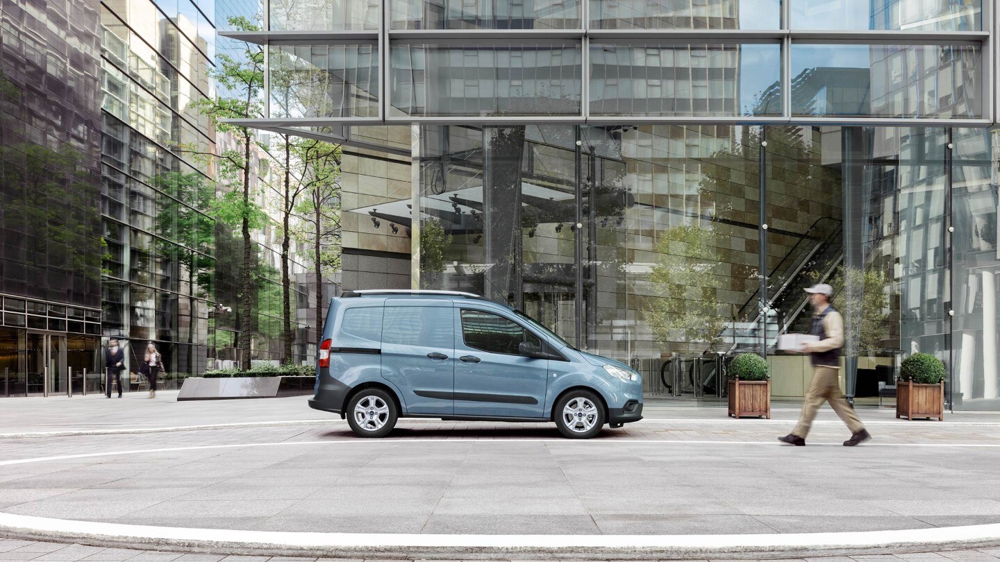 Le Transit Courier garé à proximité d’un batiment. 